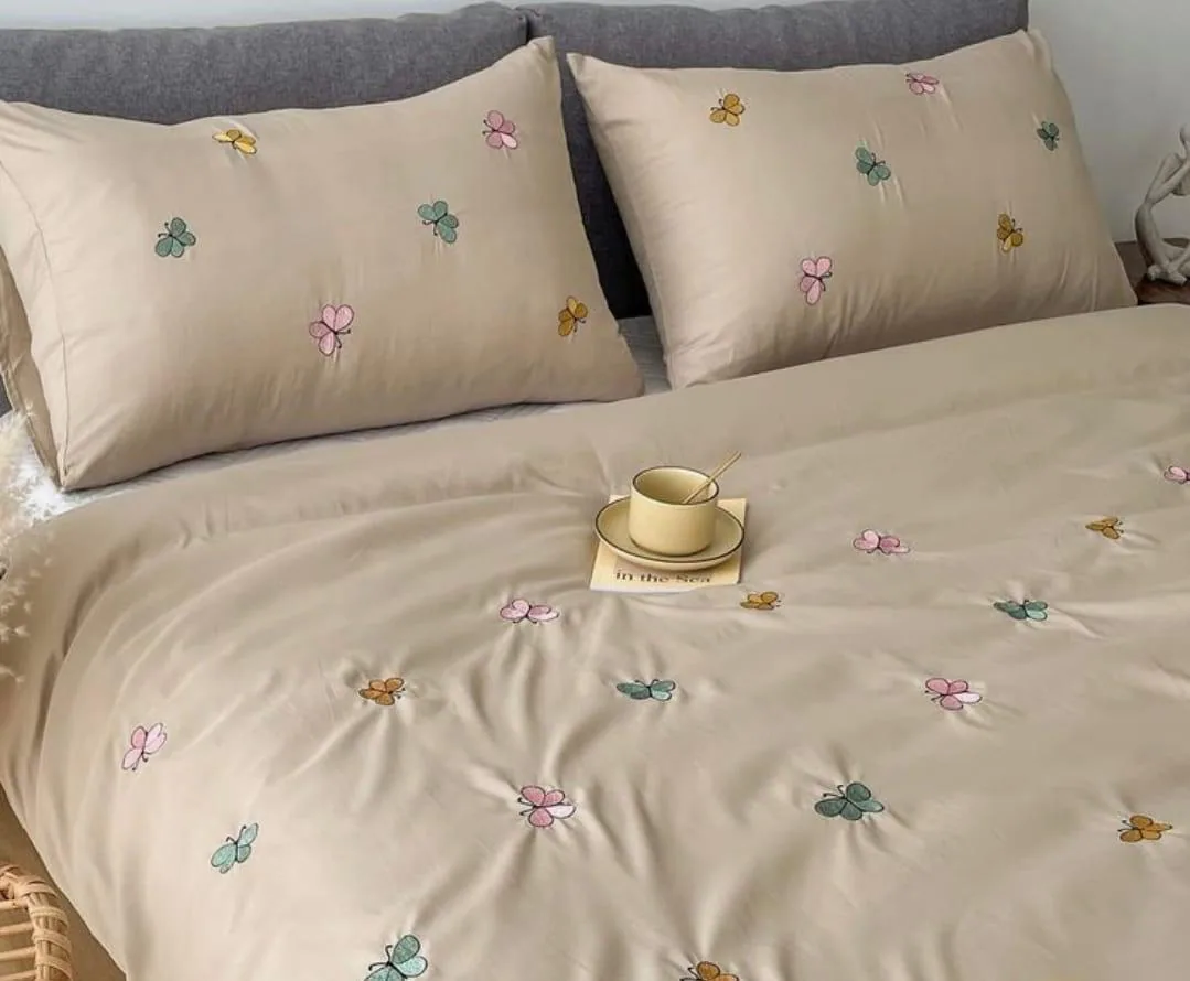 Full view of beige butterfly and floral bedsheet